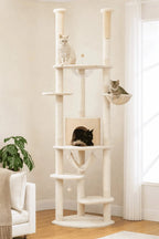 Arbre à chat réglable XXL Sérénya beige installé dans un salon lumineux avec trois chats sur ses couchages