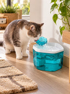 Chat buvant à la fleur surélevée de la fontaine à eau bleue Cyanéa dans un intérieur lumineux.